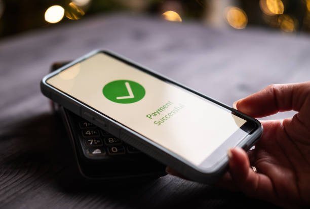 Person confirming a successful tap-to-pay transaction on a phone